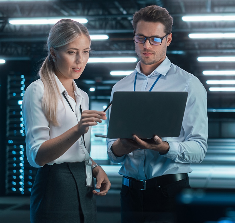 Cybersecurity analysts monitors multiple screens displaying network data, security alerts, and code in a dark operations room, focusing on protecting systems from cyber threats.