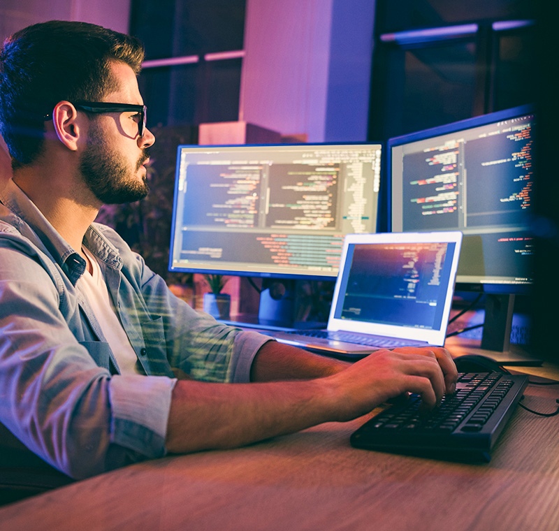 A Linux Administrator works in a modern control room, managing servers and configuring systems on multiple monitors displaying command-line interfaces and network data.